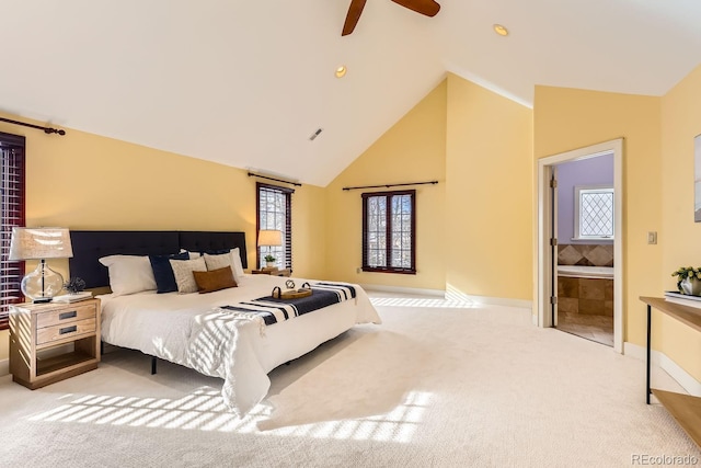 bedroom featuring light carpet, ceiling fan, multiple windows, and ensuite bath