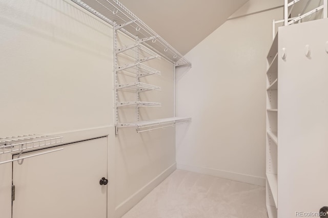 walk in closet featuring light carpet