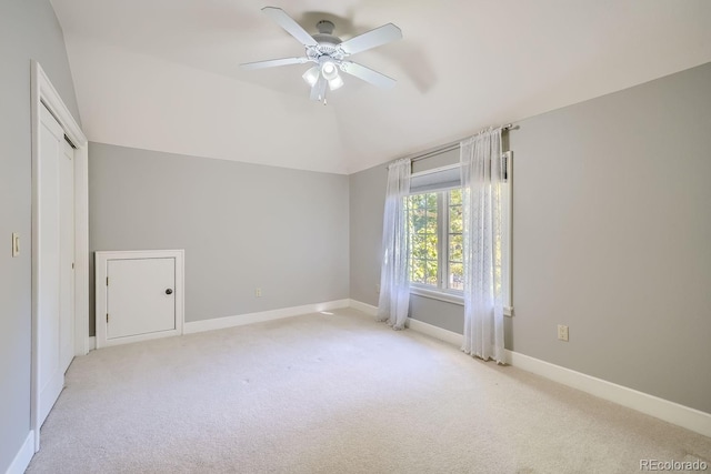 carpeted empty room with ceiling fan and lofted ceiling