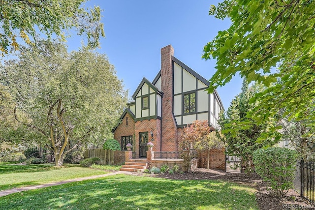 tudor-style house featuring a front yard