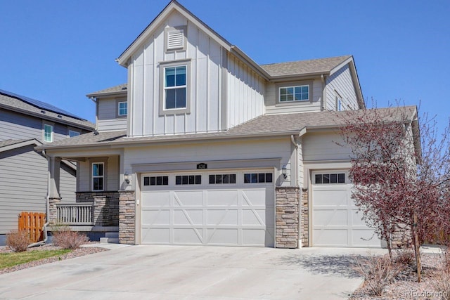 view of front of house with a garage, board and batten siding, concrete driveway, and stone siding