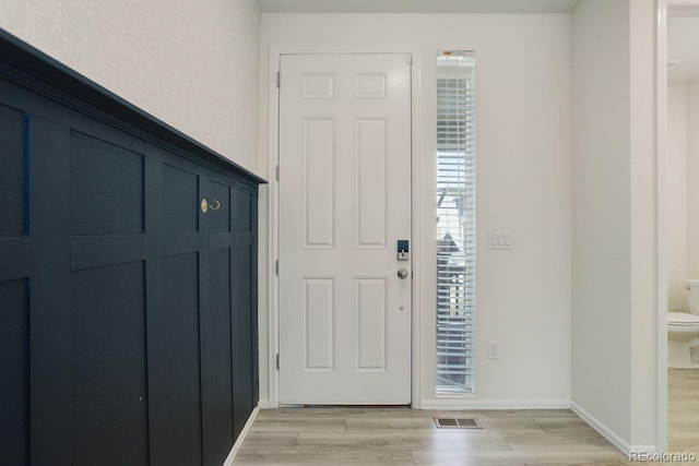 entryway featuring light wood-type flooring, baseboards, and visible vents