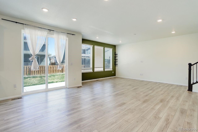 unfurnished living room featuring light wood-style floors, baseboards, recessed lighting, and visible vents