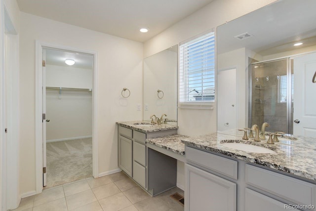 full bathroom featuring a walk in closet, tile patterned flooring, vanity, visible vents, and a stall shower