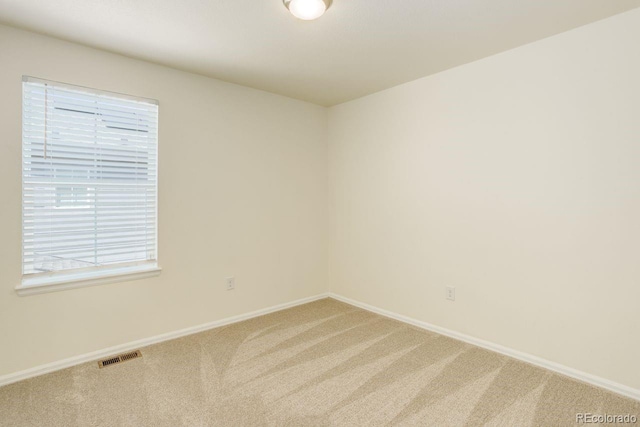 unfurnished room featuring baseboards, carpet flooring, and visible vents