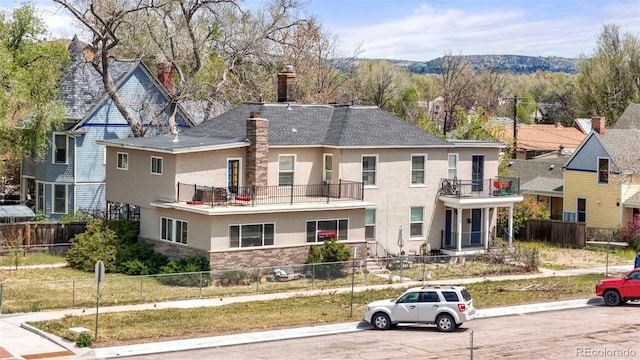 501 N Weber, Colorado Springs, CO 80903 - rear view of property featuring stucco siding, a balcony, stone siding, and a chimney