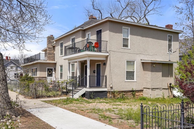501 N Weber, Colorado Springs, CO 80903 - view of front of house featuring a balcony, a chimney, and stucco siding
