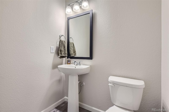 bathroom with toilet and hardwood / wood-style floors