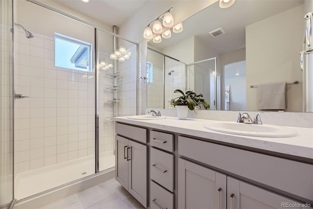 bathroom with tile patterned flooring, dual vanity, and a shower with door