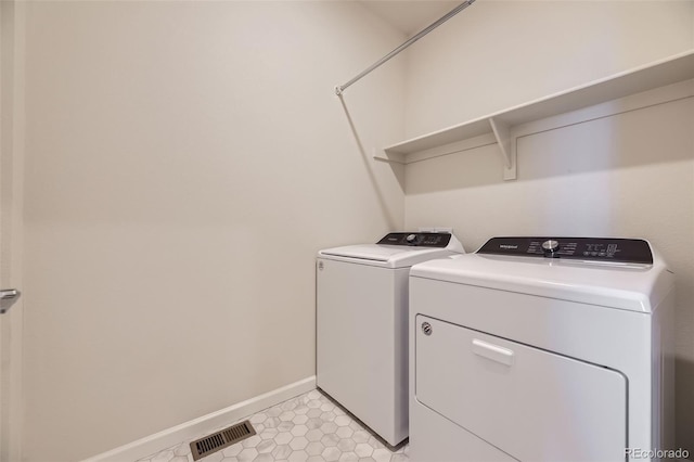 laundry area featuring separate washer and dryer and light tile patterned floors