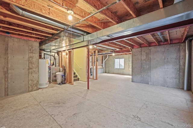 basement featuring stairs and water heater