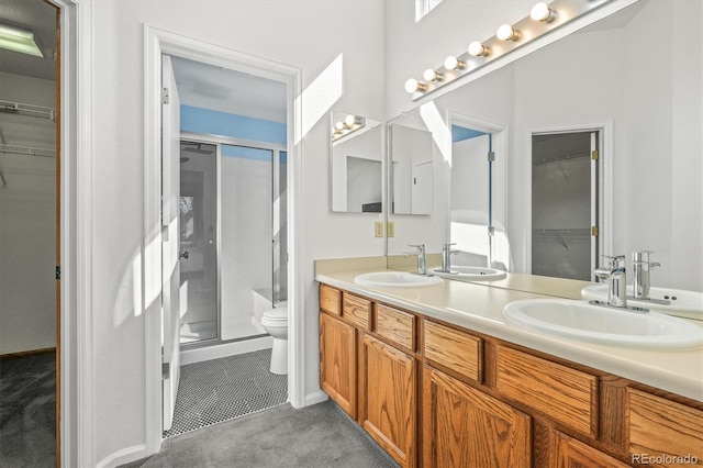 bathroom featuring double vanity, a stall shower, and a sink