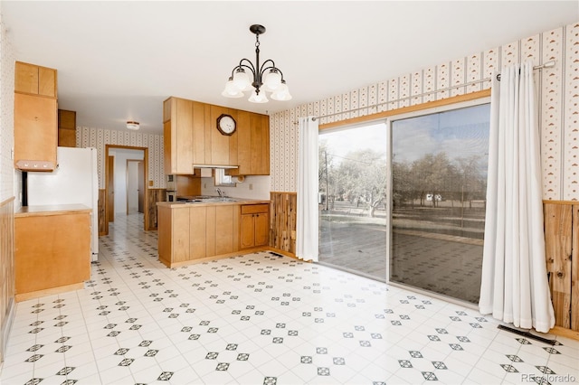 8895 Morton Rd, Niwot, CO 80503 - kitchen featuring wallpapered walls, freestanding refrigerator, a chandelier, light countertops, and a peninsula