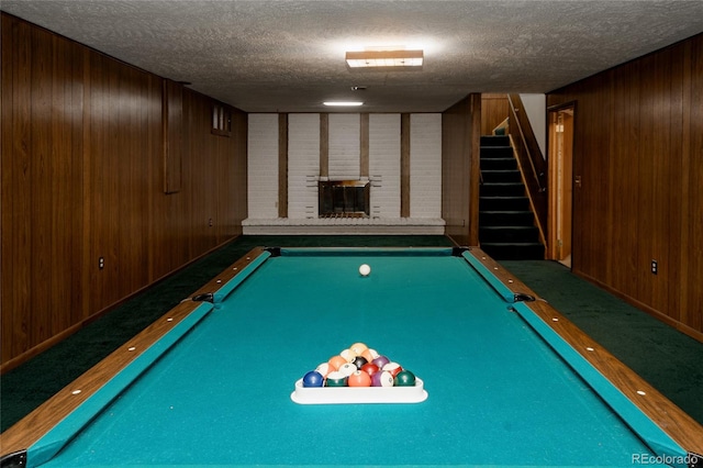 8895 Morton Rd, Niwot, CO 80503 - game room with wood walls, a textured ceiling, a brick fireplace, and pool table