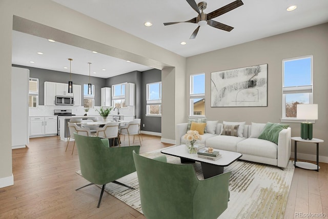 living room featuring light wood-type flooring and ceiling fan