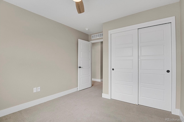 unfurnished bedroom with light carpet, a closet, and ceiling fan