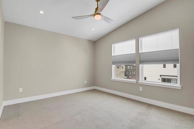 empty room featuring light carpet, vaulted ceiling, and ceiling fan