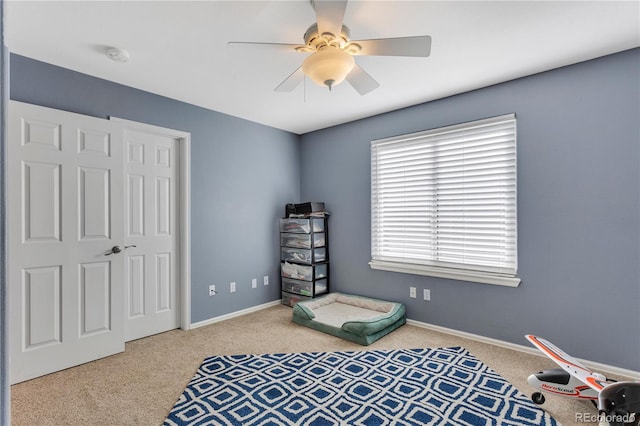 interior space featuring ceiling fan, light carpet, and a closet