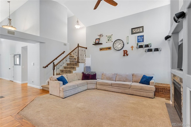 living room featuring ceiling fan, a fireplace, high vaulted ceiling, and hardwood / wood-style flooring