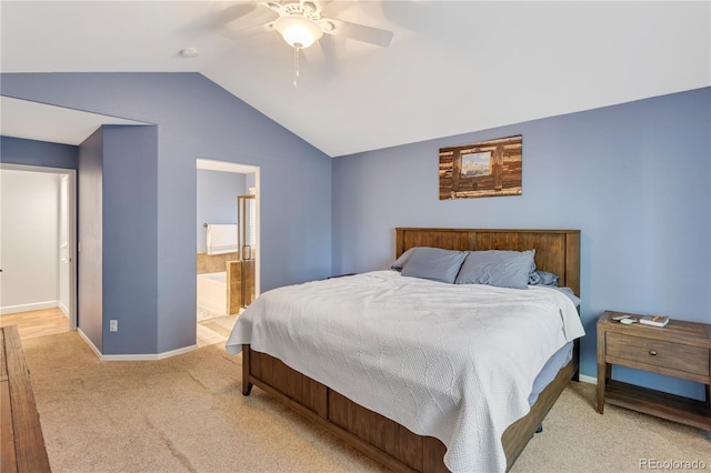 bedroom with ensuite bath, ceiling fan, light carpet, and vaulted ceiling