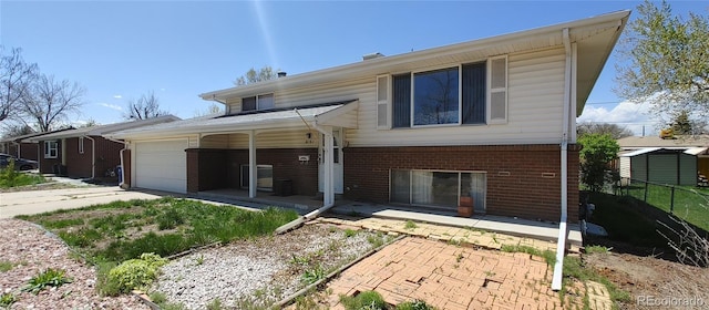 view of front of house featuring fence, covered porch, brick siding, concrete driveway, and an attached garage