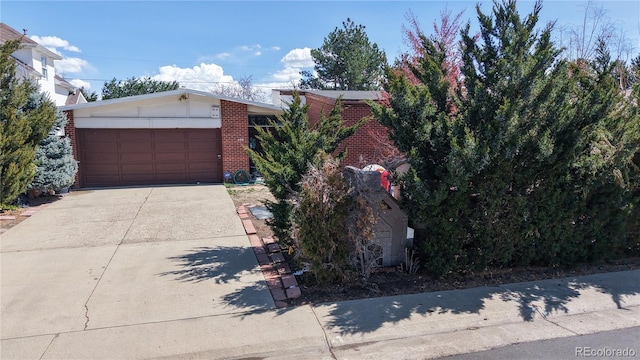 110 Forest St, Denver, CO 80220 - obstructed view of property featuring brick siding, a garage, and concrete driveway