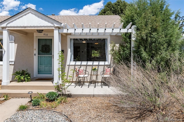 916 E Ln Salle St, Colorado Springs, CO 80907 - view of exterior entry with stucco siding, a shingled roof, and a porch