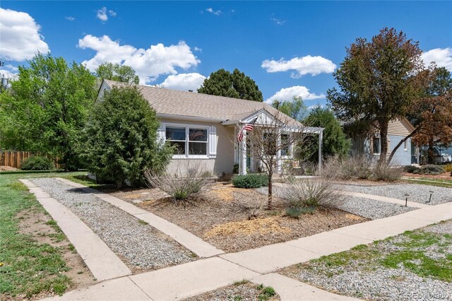 916 E Ln Salle St, Colorado Springs, CO 80907 - view of front facade featuring a pergola, stucco siding, and gravel driveway