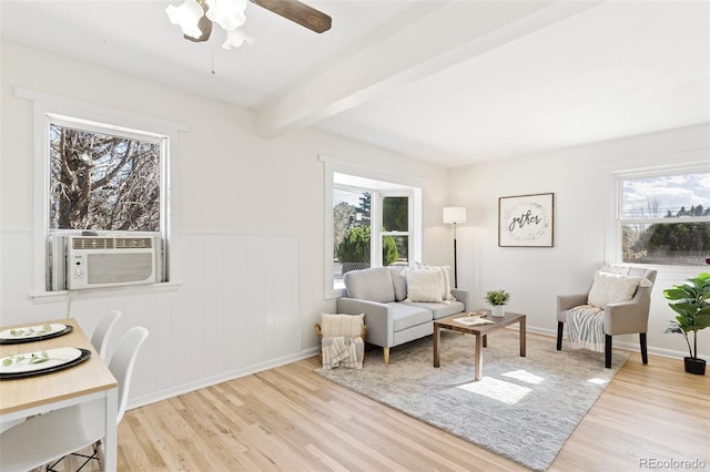 living room featuring beam ceiling, light wood-type flooring, a healthy amount of sunlight, and ceiling fan