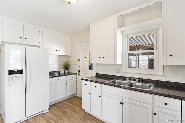 kitchen featuring sink, light hardwood / wood-style floors, white cabinetry, and white refrigerator with ice dispenser