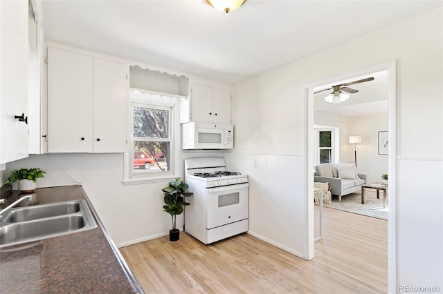 kitchen featuring ceiling fan, white cabinetry, light hardwood / wood-style flooring, sink, and white appliances