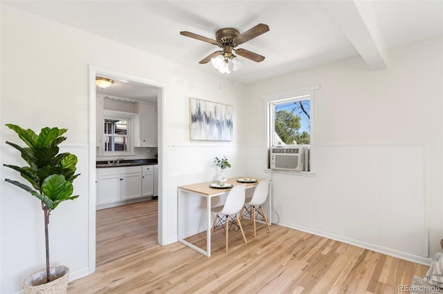 dining area featuring beamed ceiling, cooling unit, sink, light hardwood / wood-style floors, and ceiling fan