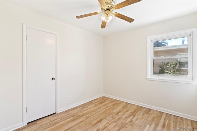 empty room with ceiling fan and light hardwood / wood-style flooring