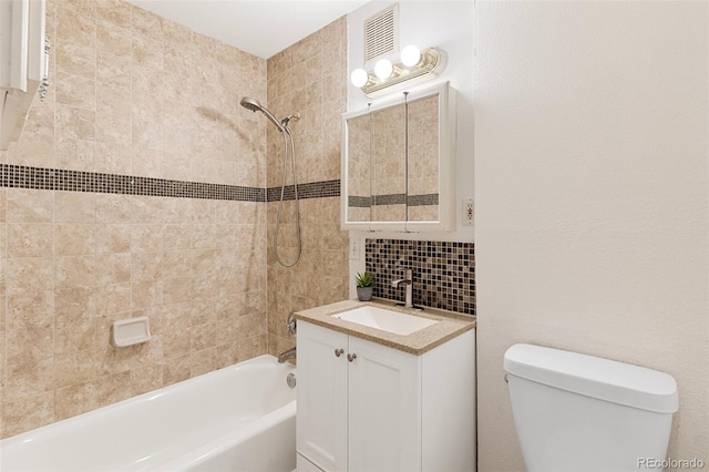 full bathroom with vanity, toilet, decorative backsplash, and tiled shower / bath