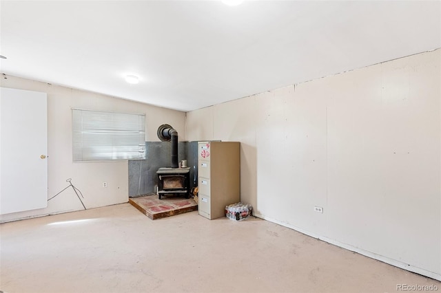 interior space with concrete flooring and a wood stove