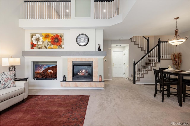10183 Grove Loop Unit D, Westminster, CO 80031 - carpeted living area with a tiled fireplace, stairs, and a high ceiling