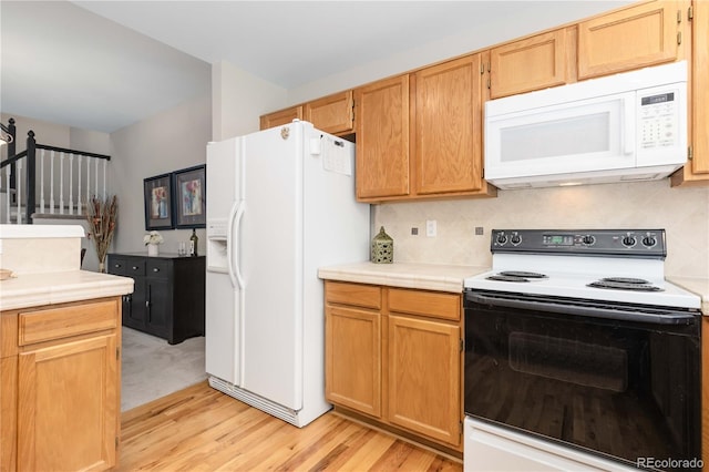 10183 Grove Loop Unit D, Westminster, CO 80031 - kitchen with white appliances, light wood-style floors, and backsplash