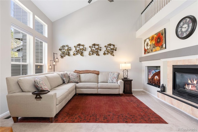10183 Grove Loop Unit D, Westminster, CO 80031 - carpeted living area with high vaulted ceiling, a tiled fireplace, and a ceiling fan