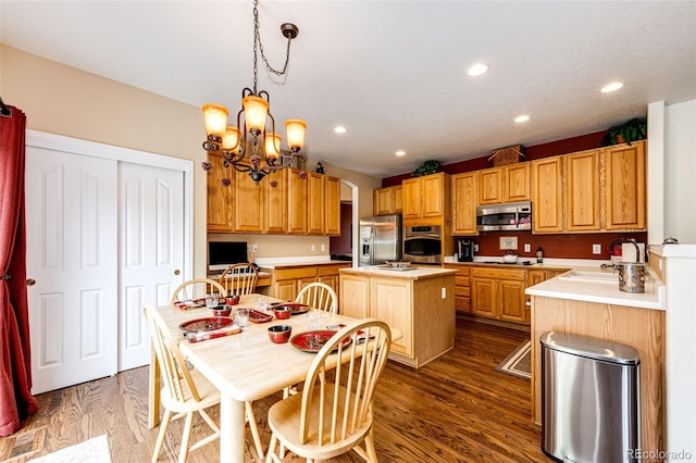 12000 Horseshoe Ln, Parker, CO 80138 - kitchen with appliances with stainless steel finishes, a sink, a center island, light countertops, and dark wood-type flooring