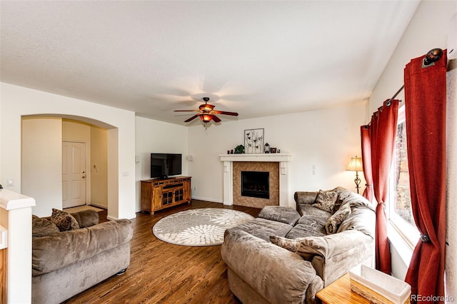 12000 Horseshoe Ln, Parker, CO 80138 - living room featuring wood finished floors, ceiling fan, arched walkways, and a tiled fireplace