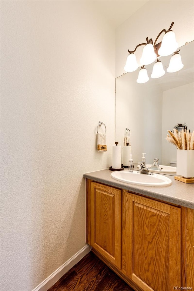 12000 Horseshoe Ln, Parker, CO 80138 - bathroom featuring vanity, wood finished floors, a chandelier, and baseboards