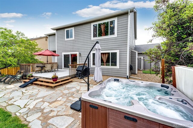 12000 Horseshoe Ln, Parker, CO 80138 - back of property with outdoor dining area, a hot tub, a wooden deck, and a patio
