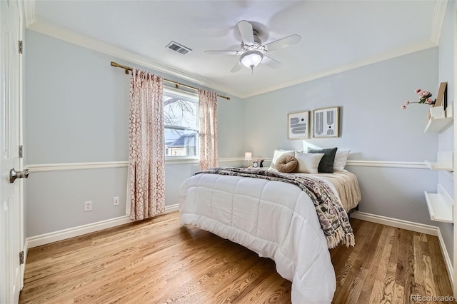 bedroom with ornamental molding, ceiling fan, and light hardwood / wood-style floors