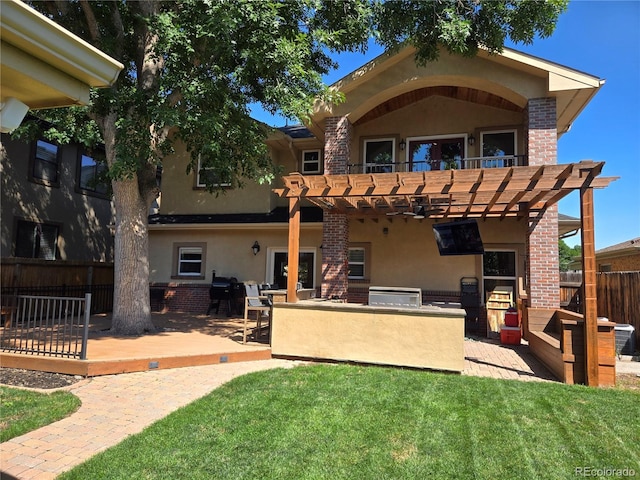 rear view of house with a patio, a pergola, and a lawn