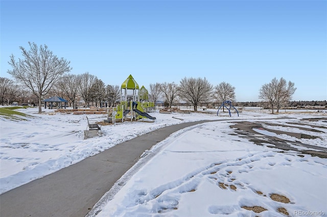 yard covered in snow featuring a playground