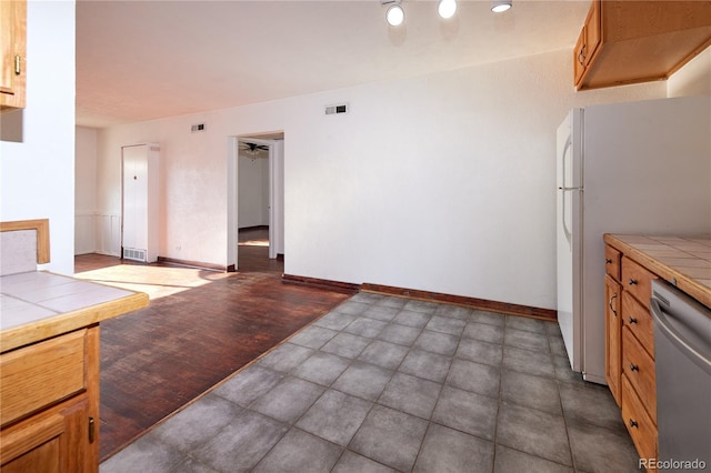 kitchen featuring dishwasher, tile counters, refrigerator, and ceiling fan