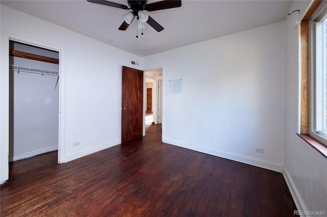 unfurnished bedroom with dark hardwood / wood-style flooring, a closet, and ceiling fan