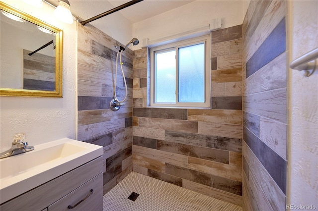 bathroom with a tile shower and vanity