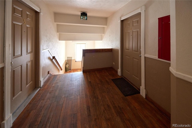 hallway with dark hardwood / wood-style flooring and a textured ceiling