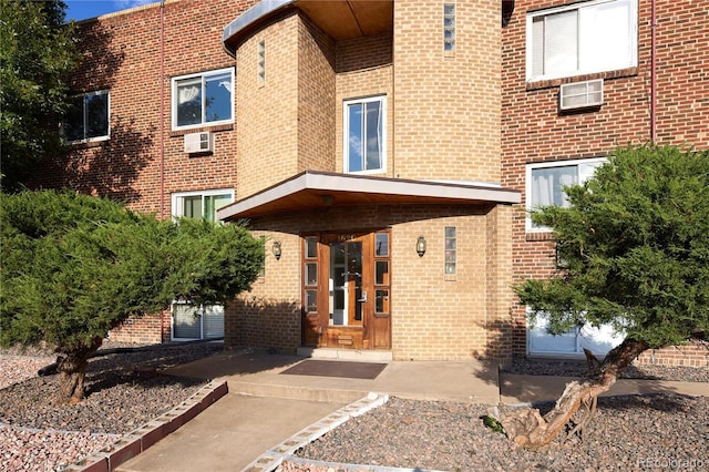 exterior space with a wall mounted air conditioner